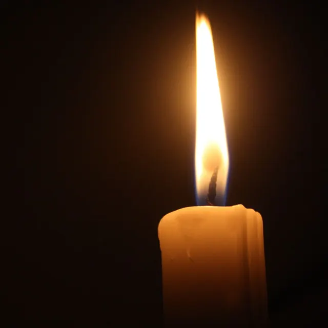 A lit candle, the quiet light of remembrance