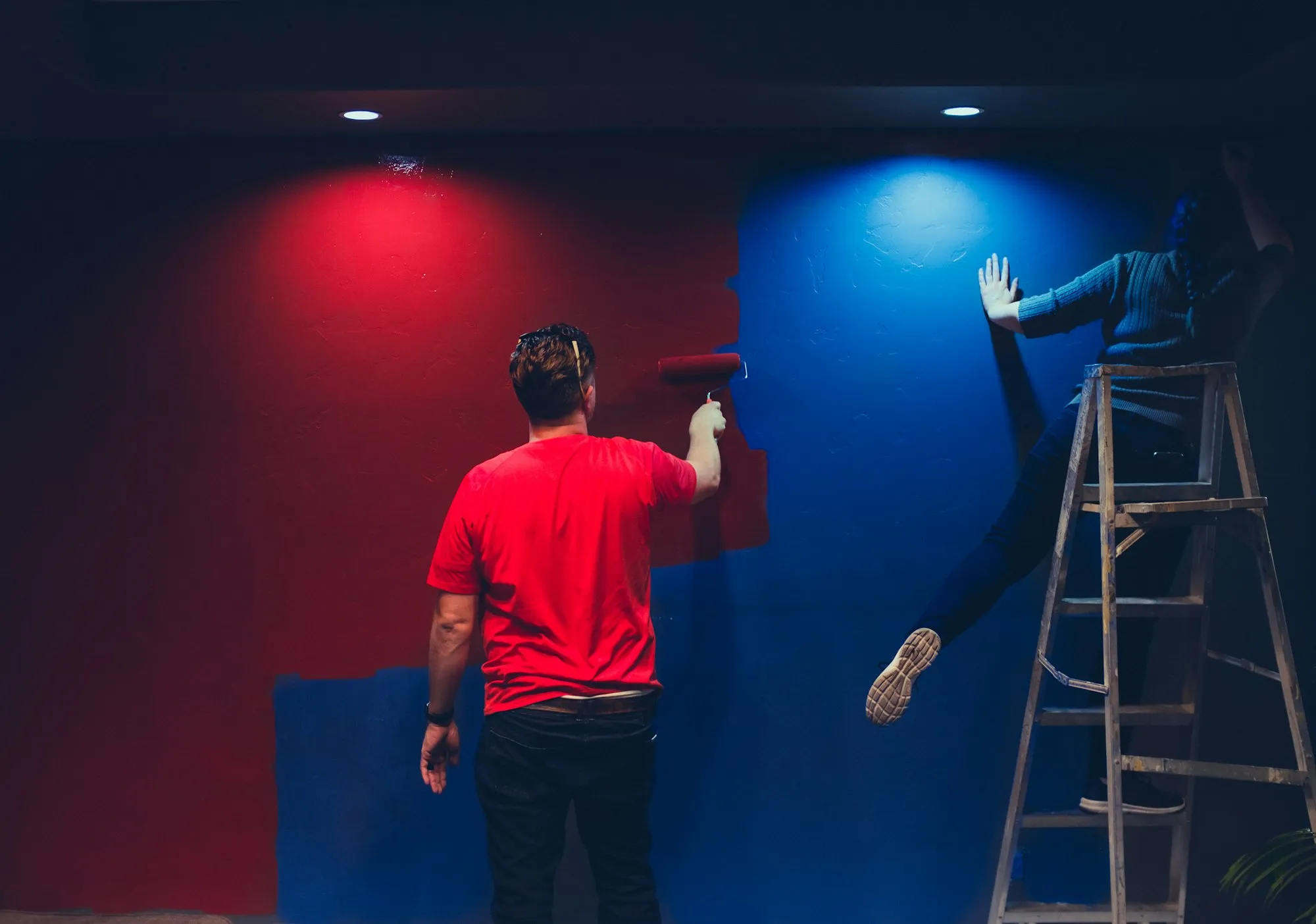 Two craftspeople painting a two-tone accent wall